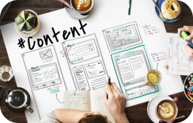 A workspace featuring a content creation layout with sketches and notes on paper surrounded by coffee cups and stationery.