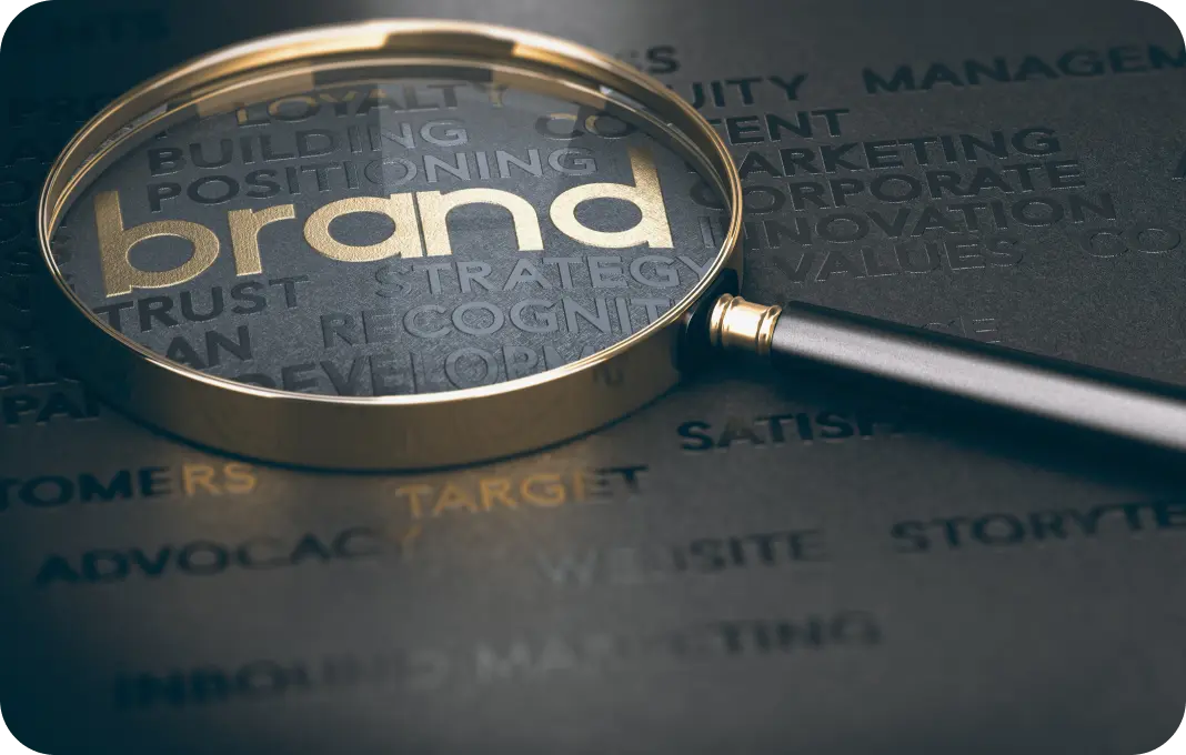 A magnifying glass held over the word 'brand' amidst various terms related to branding, such as trust, strategy, and recognition.