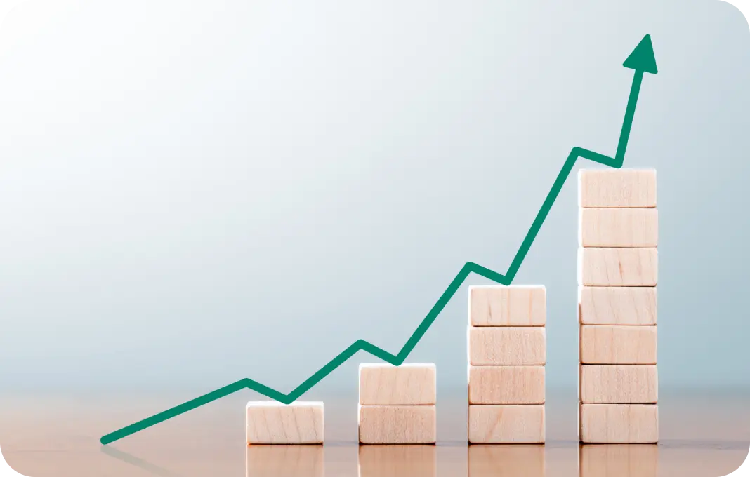 The image depicts a bar graph with a trend line indicating growth. Four sets of wooden blocks increase in height from left to right, symbolizing an upward progression.